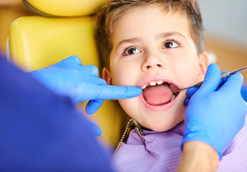 The dentist checking the teeth of  boy teenager in the dentist's office.